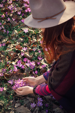 Sensual red head girl trying to seize the beauty, feel the touch of Spring. Inspired by nature. High angle view. Wanderlust travel concept.の写真素材