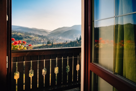 Open door that leads to a balcony overlooking the marvelous view of mountain nature with a taste of  peace and adventures.の写真素材