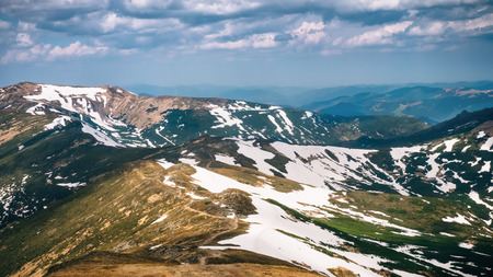Mountain spring landscape with snow spot on the rocksの写真素材
