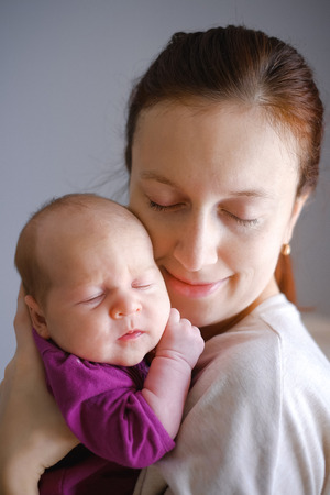 Mother touch to face baby and kiss. Love and positive emotions oh happy familyの写真素材