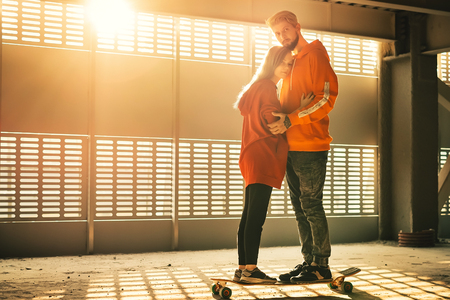 Teenager couple with long boards at abandoned parking at sunsetの写真素材