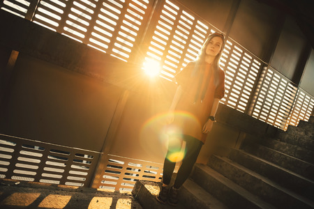 Portrait of hipster girl with pink long hair and urban style at abandoned parking at sunsetの写真素材