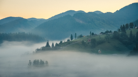 Mountain forest, hills and foggy landscape at sunriseの写真素材
