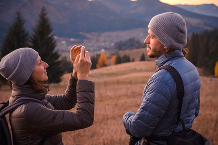 Happy couple feel freedom and enjoy the beautiful autumn forest in the mountainsの写真素材