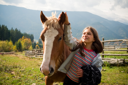 Best friends little girl and horse, ride and therapy in action, at the mountain villageの写真素材