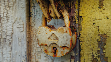 Old closed vintage metal lock on wooden doorの写真素材