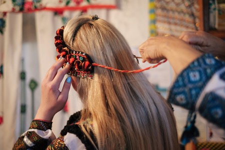 Beautiful caucasian woman wearing ethnic and traditional of the Carpathian mountain Ukrainian clothes. Village background in the autumn.の写真素材