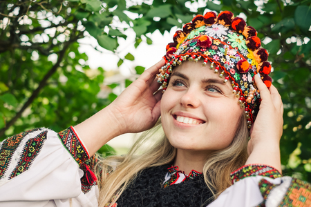 Beautiful caucasian woman wearing ethnic and traditional of the Carpathian mountain Ukrainian clothes. Village background in the autumn.の写真素材
