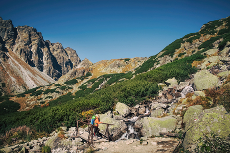 Young hiker in fantastic mountain landscape in spring season near waterfall in High tatrasの写真素材