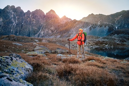 Young hiker in colorful fantastic mountain landscape at gold sunset near Hincovo Pleso lake in High tatrasの写真素材