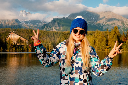 Young hiker in colorful fantastic mountain landscape at gold autumn sunset near Strbske Pleso lake in High Tatrasの写真素材