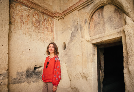 Tourist woman walking in Cappadocia and explore old church ruins. Travel in Turkey