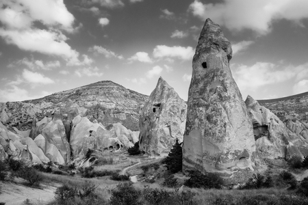Beautiful black and white mountain landscape in Cappadocia Rose valley with cave house and ancient church ruins, Turkey, Goremeの写真素材
