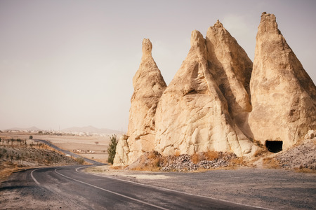 Beautiful empty road through dry sand desert and canyon landscape, Cappadocia Goreme village, Turkeyの写真素材