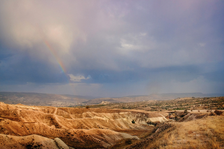 Colorful sunset with stormy and dark blue sky in mountain canyon in Cappadocia landscape Rose valley in Goreme village, Turkeyの写真素材