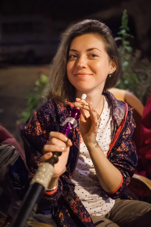 Beautiful tourist woman enjoy hookah while traveling in Istanbul, Turkey. High ISO shooting with grainの写真素材