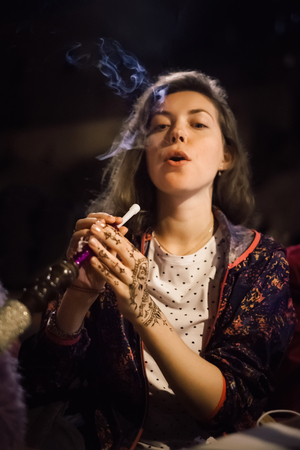 Beautiful tourist woman enjoy hookah while traveling in Istanbul, Turkey. High ISO shooting with grainの写真素材