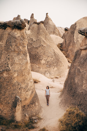 Young tourist woman hiking and enjoying mountain desert landscape while traveling in Cappadocia, turkeyの写真素材