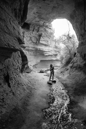 Young tourist woman hiking and and explore underground cave city in mountain desert landscape while traveling in Cappadocia, Turkeyの写真素材