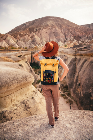 Young tourist woman hiking and enjoying mountain desert landscape while traveling in Cappadocia, turkeyの写真素材