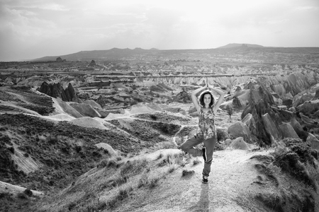 Woman practice tree yoga pose in nature. Black and white Cappadocia mountain landscape with beautiful skyの写真素材