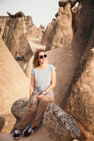 Young tourist woman hiking and enjoying mountain desert landscape while traveling in Cappadocia, turkeyの写真素材
