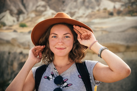 Portrait of young tourist woman hiking and enjoying mountain desert landscape while traveling in Cappadocia, turkeyの写真素材