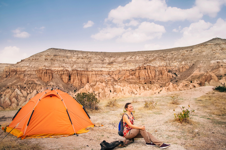 Small tourist people in big beautiful mountain landscape in Cappadocia rose valley. Woman enjoy view while traveling with tent in Turkeyの写真素材