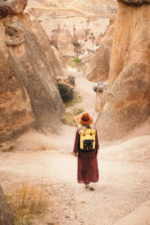 Young tourist woman hiking and enjoying mountain desert landscape while traveling in Cappadocia, turkeyの写真素材