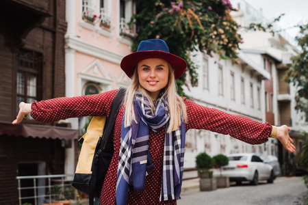 Happy beautiful tourist woman in hat and dress walking on Istanbul street and enjoy arabic city architecture, Turkeyの写真素材