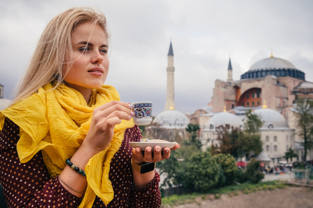 Woman travel in Istanbul and and drink turkey coffee in cafe near Hagia Sophia famous islamic Landmark mosque, Travel to Istanbul, Turkey backgroundの写真素材