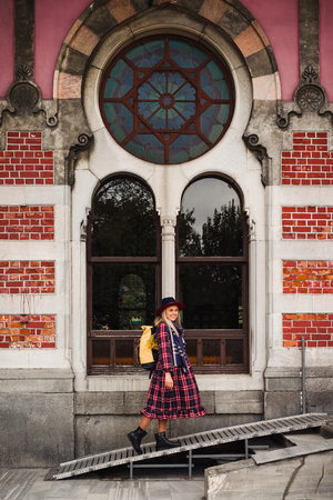 Travel to Turkey. Happy beautiful tourist woman in hat and dress walking near Orient Express railway station in Istanbul street and enjoy city architectureの写真素材