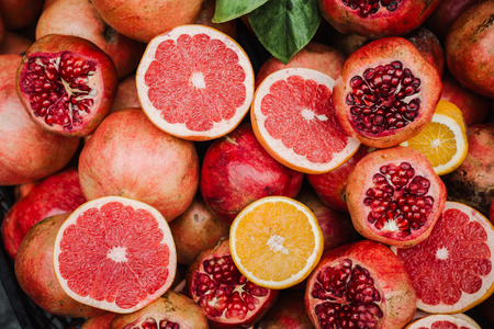 Heap of ripe citrus fruits and slice of them on the market for juiceの写真素材