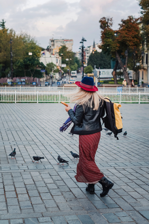 Happy beautiful tourist woman in hat and dress walking on Istanbul street and enjoy arabic city architecture, Turkeyの写真素材