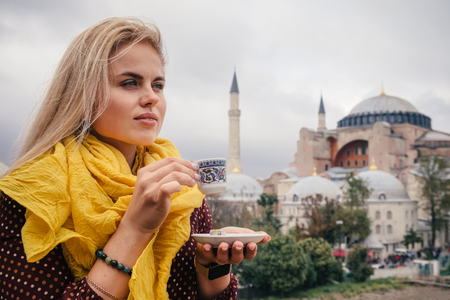 Woman travel in Istanbul and and drink turkey coffee in cafe near Hagia Sophia famous islamic Landmark mosque, Travel to Istanbul, Turkey backgroundの写真素材