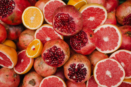 Heap of ripe citrus fruits and slice of them on the market for juiceの写真素材