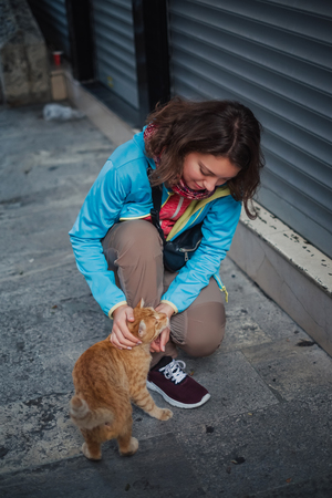 Portrait of beautiful woman that paying with red homeless cat. Love and fun emotion for petsの写真素材