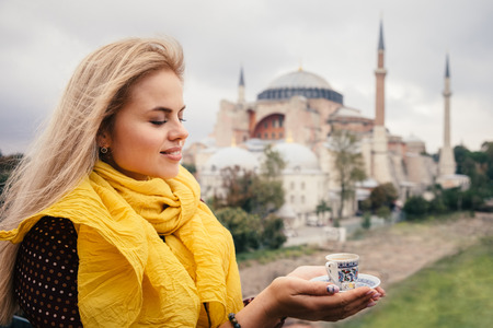 Woman travel in Istanbul and and drink turkey coffee in cafe near Hagia Sophia famous islamic Landmark mosque, Travel to Istanbul, Turkey backgroundの写真素材