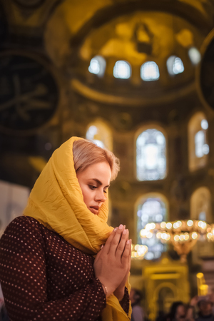 Christian Religion Concept. Young woman praying and feel God blessing in her heart in Hagia Sophia, Istanbul, Turkeyの写真素材