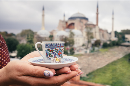 Cup of turkey coffee in tourist woman hands on Hagia Sophia famous islamic Landmark mosque, Travel to Istanbul, Turkey backgroundの写真素材