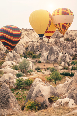Beautiful hot air balloons flying over beautiful Goreme landscape at gold sunrise. Cappadocia is famous travel destination with limestone mountains, Turkeyの写真素材