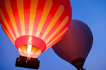 Close-up colorful big hot air balloons flying over beautiful Goreme village landscape at sunrise. Cappadocia beautiful mountains, Turkey. High ISO image with grainの写真素材