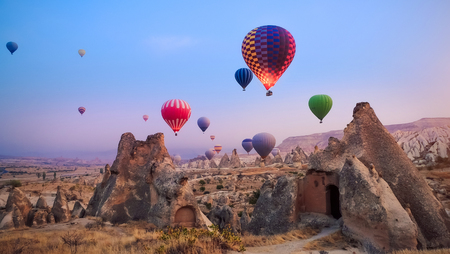 Close-up colorful big hot air balloons flying over beautiful Goreme village landscape at sunrise. Cappadocia is famous travel destination with beautiful limestone mountains, Turkeyの写真素材