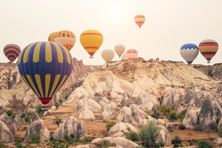 Beautiful hot air balloons flying over beautiful Goreme landscape at gold sunrise. Cappadocia is famous travel destination with limestone mountains, Turkeyの写真素材