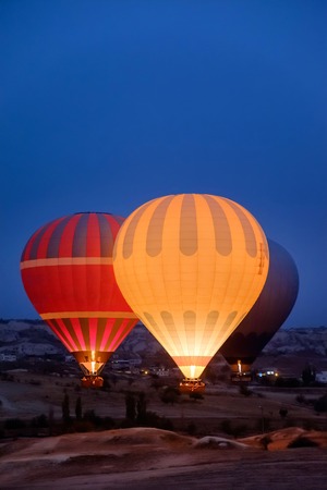 Close-up colorful big hot air balloons flying over beautiful Goreme village landscape at sunrise. Cappadocia beautiful mountains, Turkey. High ISO image with grainの写真素材