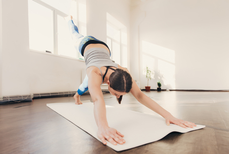 Happy smiling caucasian yoga instructor practicing yoga on in white studio at the morningの写真素材