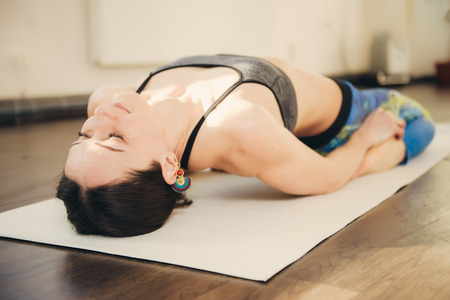 Happy smiling caucasian yoga instructor practicing yoga on in white studio at the morningの写真素材