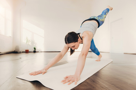Happy smiling caucasian yoga instructor practicing yoga on in white studio at the morningの写真素材
