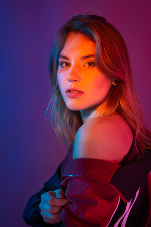 Retro style fashionable woman posing in purple, blue, and pink lights. Fashion back to 80s - 90s new trend conceptの写真素材