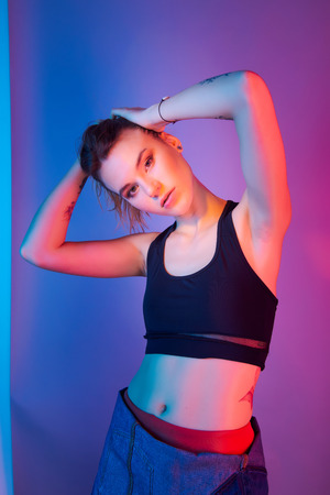 Retro style fashionable woman posing in purple, blue, and pink lights. Fashion back to 80s - 90s new trend conceptの写真素材